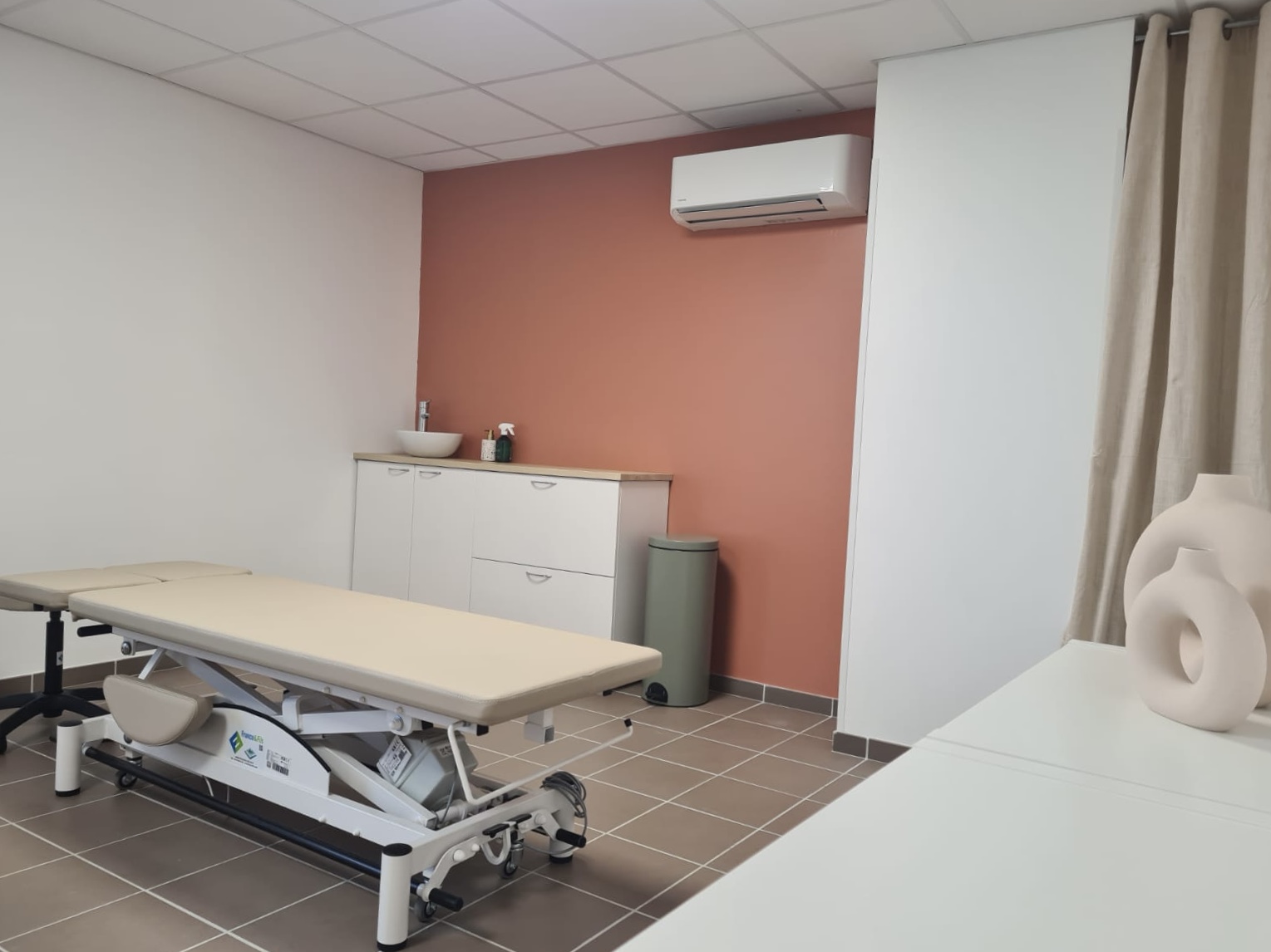 Le cabinet d'ostéopathie de Clélia Sellier à Nanteuil-le-Haudouin, table de consultation et mur terracotta